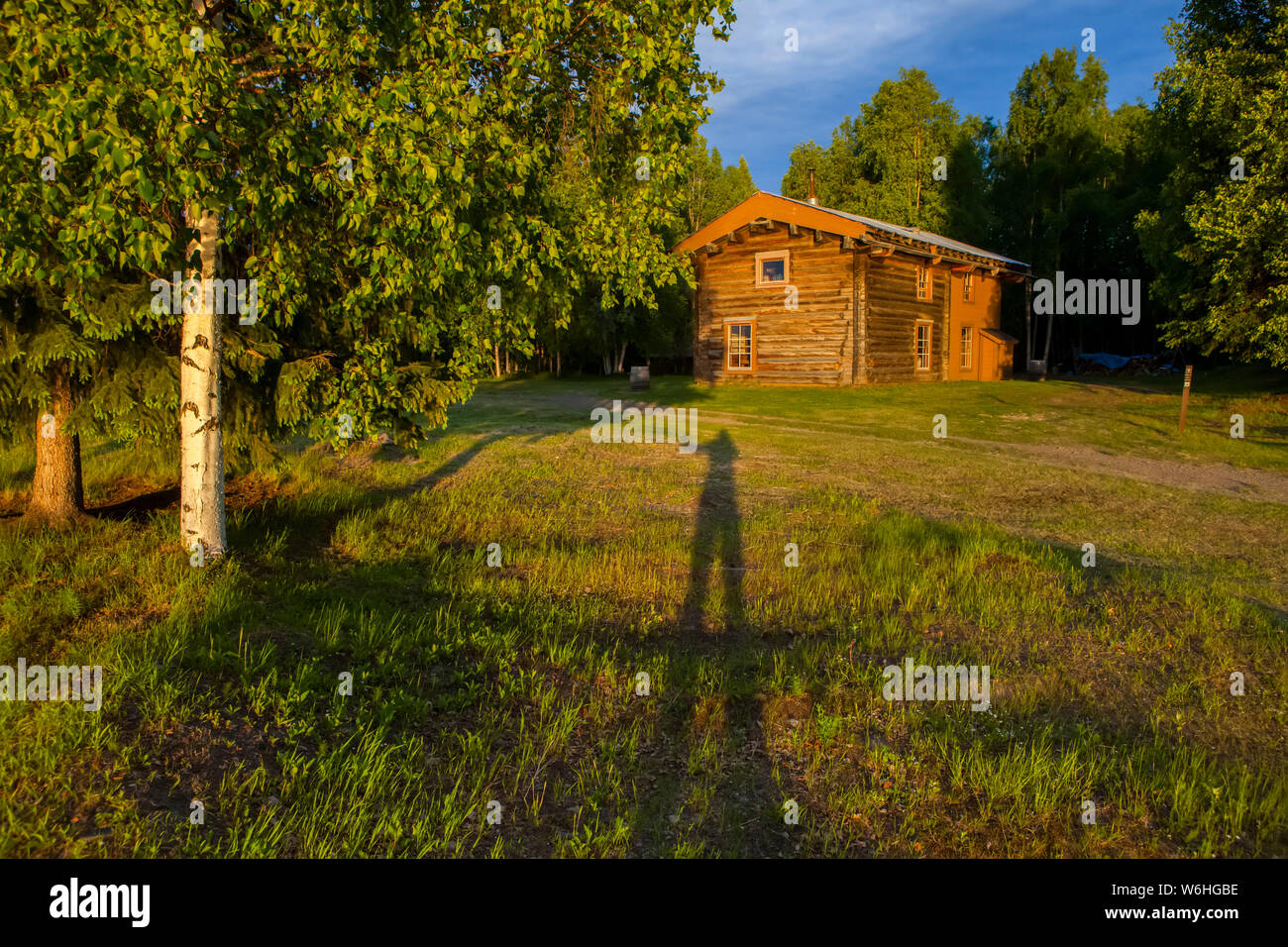 Slaven's Roadhouse on a sunny, summer evening with a shadow of a person waving, Yukon–Charley Rivers National Preserve Stock Photo