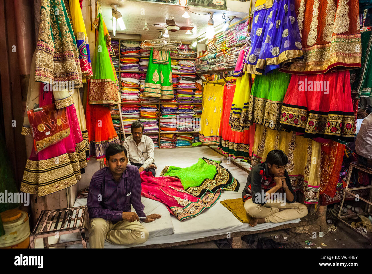 Shop keepers avoid eye contact while waiting for customers in a Sari market in Jaipur, Rajasthan, India. Stock Photo