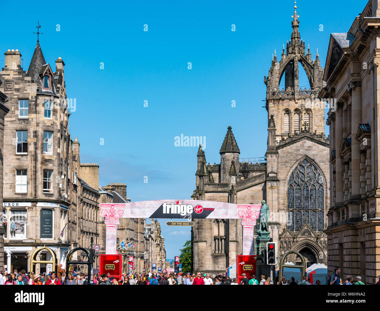 Royal Mile, Edinburgh, Scotland, United Kingdom, 1 August 2019. On the day before the official opening of the Fringe festival, the centre of the city along its main tourist route is heaving with visitors. The Fringe grows each year and residents question whether continued growth is sustainable.  The Virgin Money sponsored street venue with St Giles Cathedral Stock Photo