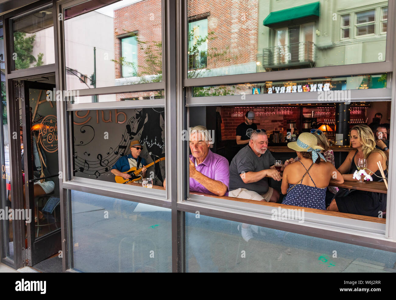 ASHEVILLE, NC, USA-27 JULY 19: The Asheville Club, a bar on Haywood Street,  opens the windows on a sunny, summer day. A guitarist entertains Stock  Photo - Alamy
