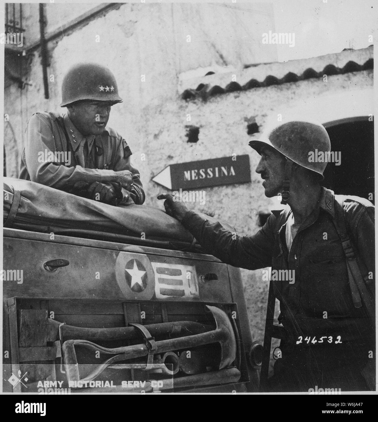 Lieutenant Colonel Lyle Bernard, Colorado, 30th Infantry Regiment., a prominent figure in the second daring amphibious landing behind enemy lines on Sicily's north coast, discusses military strategy with Lieutenant General George S. Patton. Near Brolo.; General notes:  Use War and Conflict Number 1024 when ordering a reproduction or requesting information about this image. Stock Photo