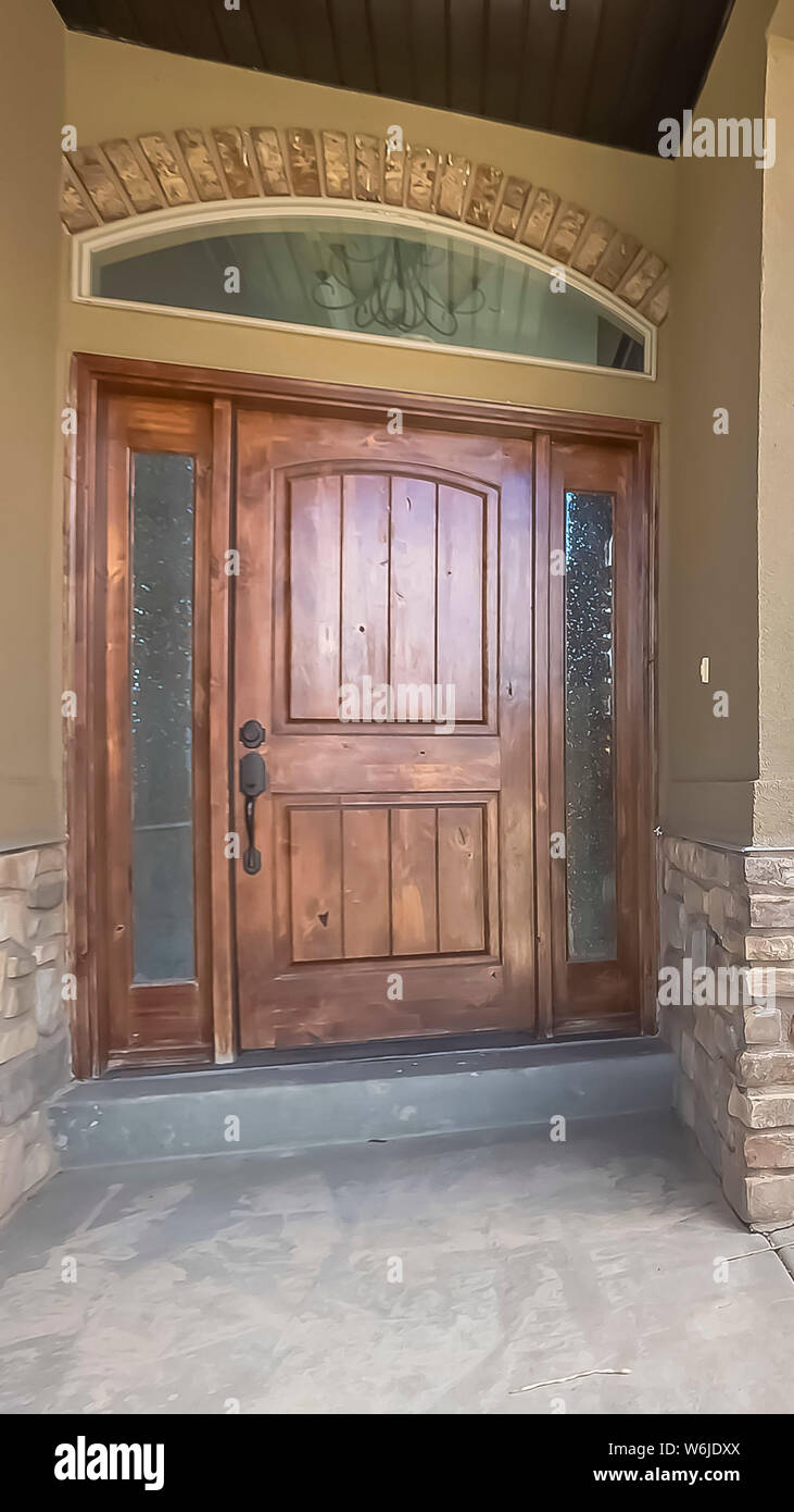 Vertical Frame Home Facade With Brown Wood Door Frosted Sidelights And Arched Transom Window Stock Photo Alamy