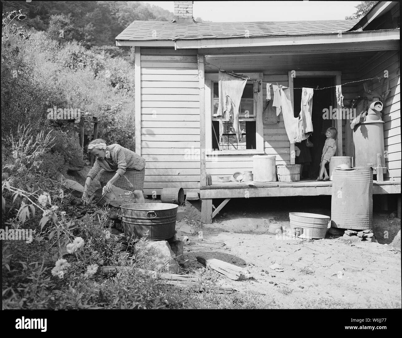 Mrs. Bill Daniels, wife of a miner, getting coal for her kitchen range