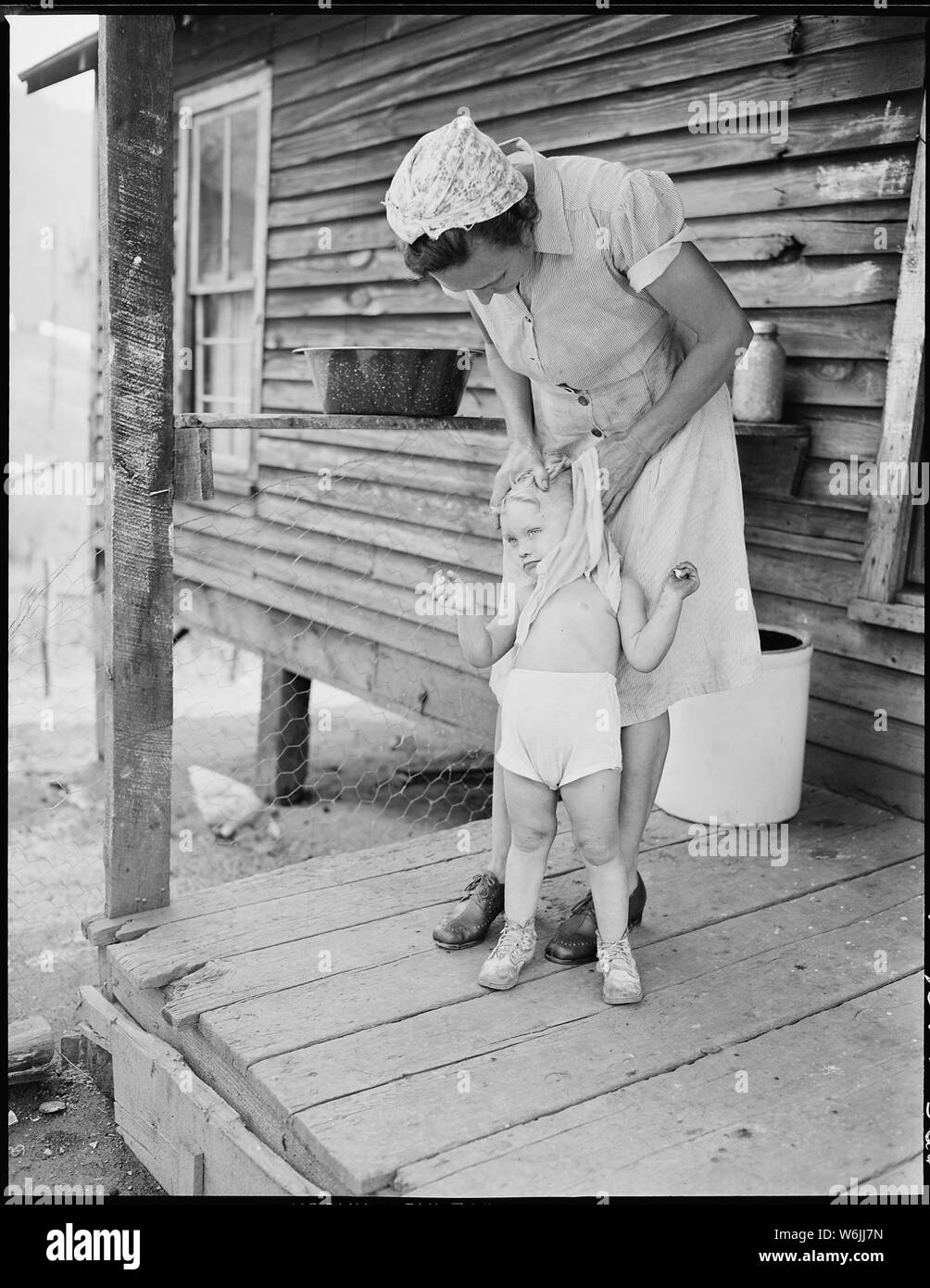 Mrs. Blaine Sergent washes her grandchild Freddy's face. P V & K Coal Company, Clover Gap Mine, Lejunior, Harlan County, Kentucky. Stock Photo