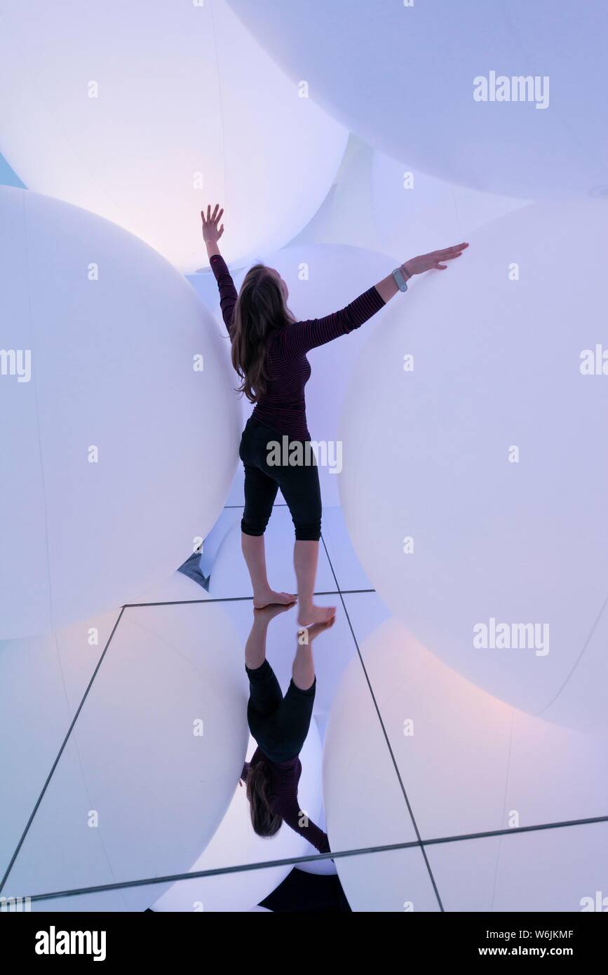 Young woman, Large illuminated spheres, LED installation in the Digital Art Museum, TeamLab Planets, Koto City, Tokyo, Japan Stock Photo