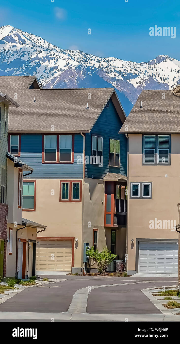 Vertical Road amid multi storey homes under cloudy blue sky on a sunny ...