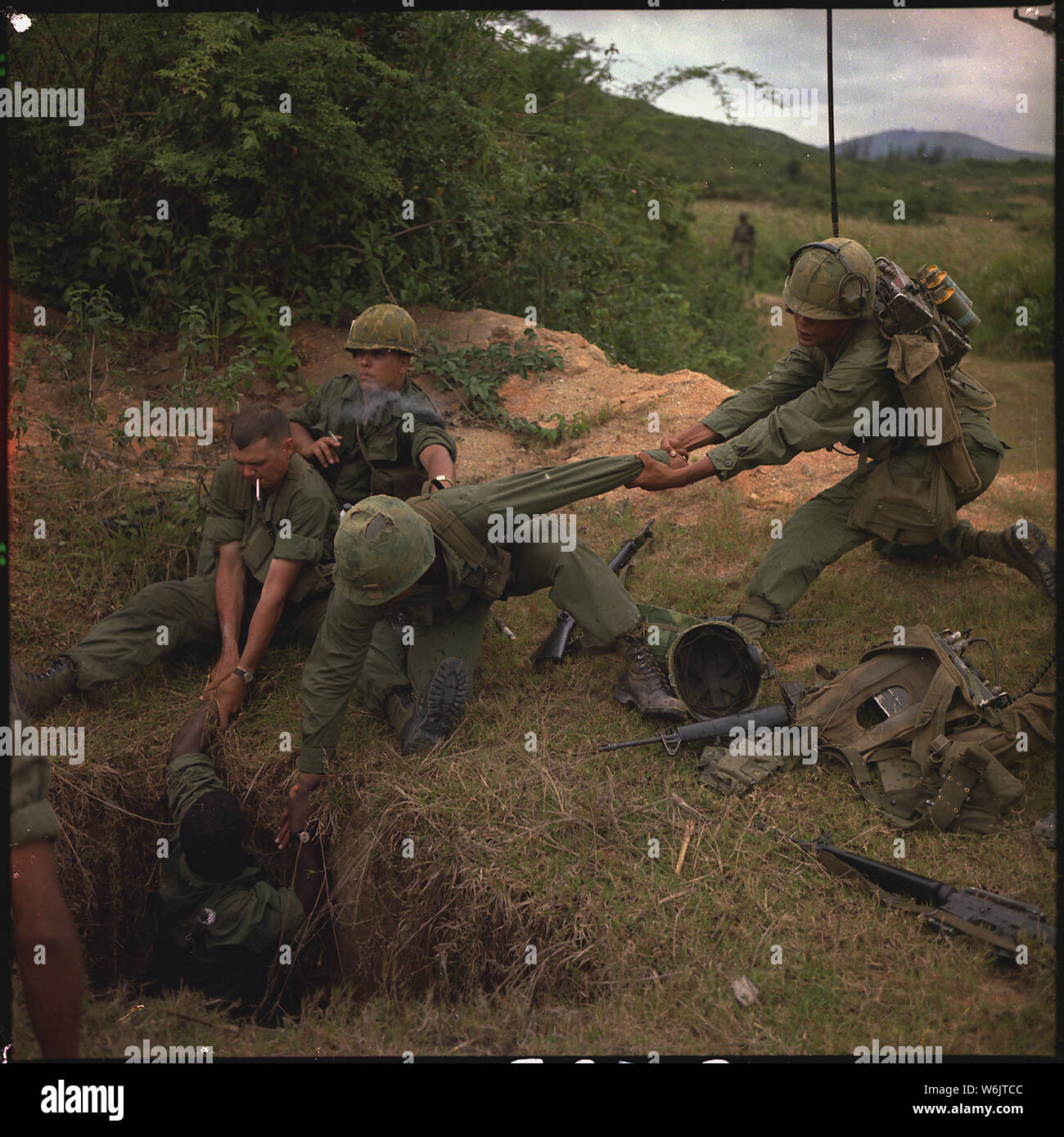 Operation Oregon, a search and destroy mission conducted by an infantry platoon of Troop B, 1st Reconnaissance Squadron, 9th Cavalry, 1st Cavalry Division (Airmobile), three kilometers west of Duc Pho, Quang Ngai Province. An infantryman is lowered into a tunnel by members of the reconnaissance platoon. Stock Photo