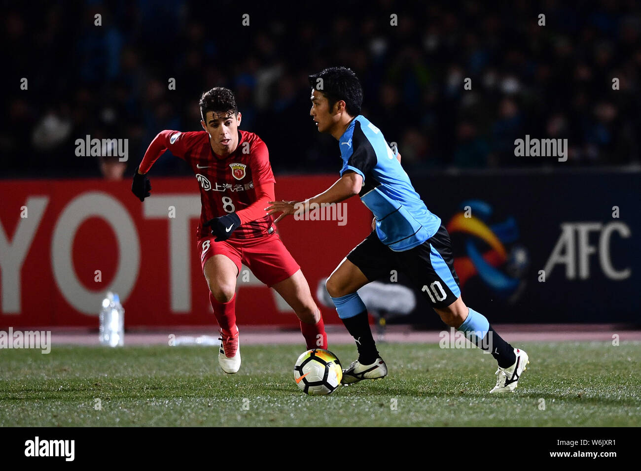 Brazilian football player Oscar, left, of China's Shanghai SIPG challenges Ryota Oshima of Japan's Kawasaki Frontale in their Group F match during the Stock Photo