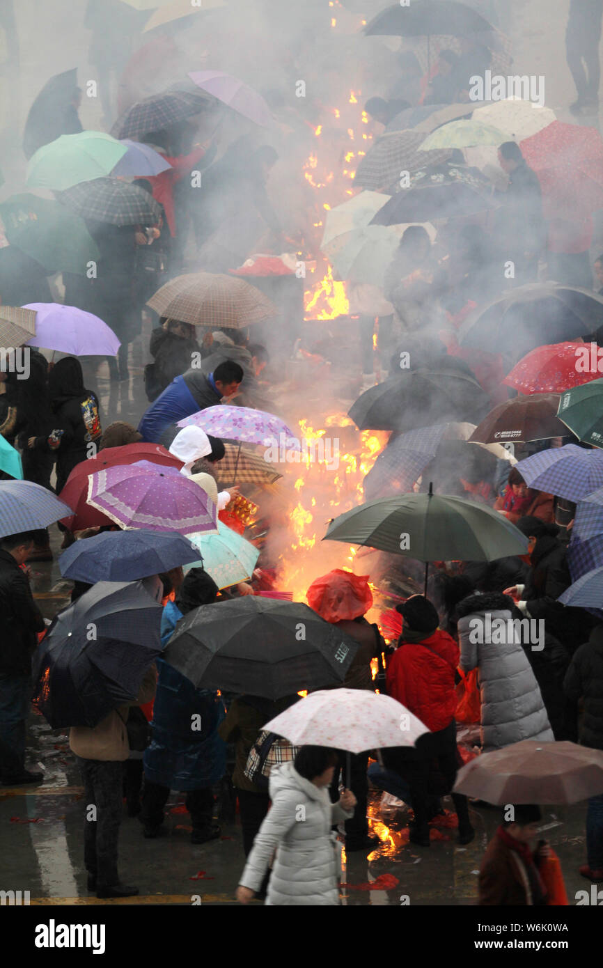 Chinese worshippers burn incense sticks to pray for wealth and ...