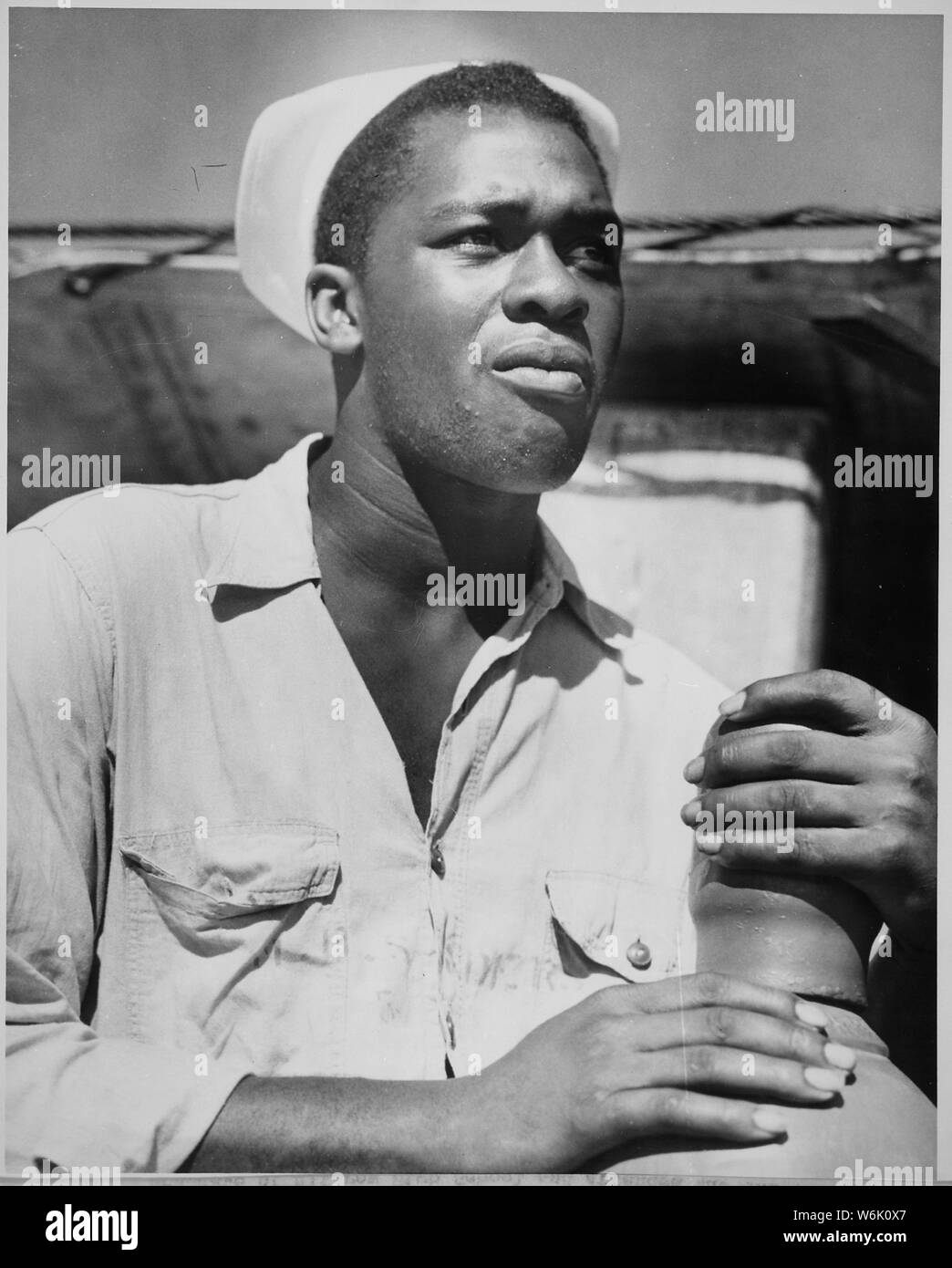 WWII photo Sailor of the US Coast Guard Charles Tyner examines his helmet 78# 