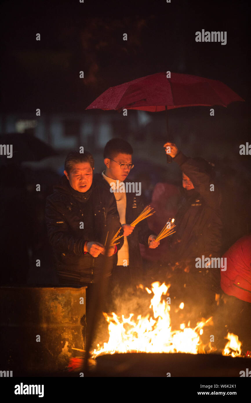 Chinese worshippers burn incense sticks to pray for wealth and ...