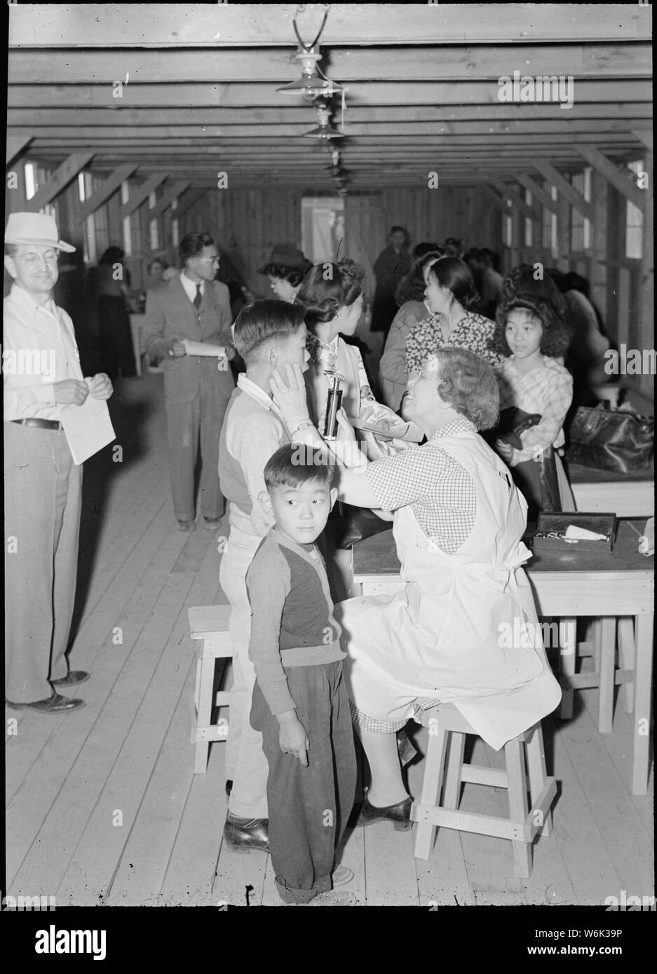 Poston, Arizona. Evacuees of Japanese ancestry are given a preliminary medical examination upon arr . . .; Scope and content:  The full caption for this photograph reads: Poston, Arizona. Evacuees of Japanese ancestry are given a preliminary medical examination upon arrival at this War Relocation Authority center. Stock Photo