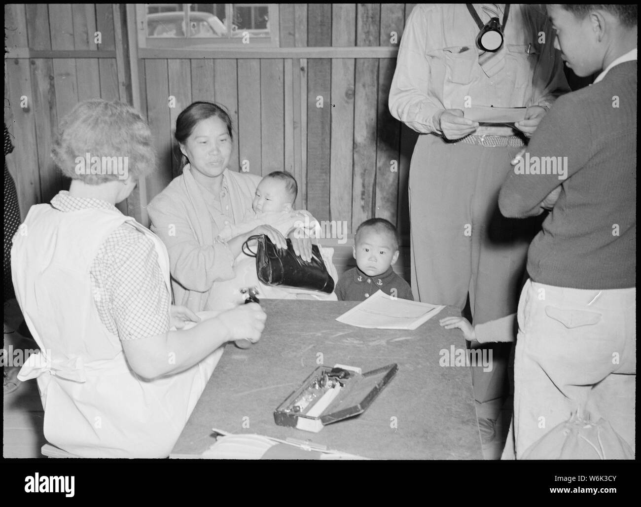 Poston, Arizona. Evacuees of Japanese ancestry are given a preliminary medical examination upon arr . . .; Scope and content:  The full caption for this photograph reads: Poston, Arizona. Evacuees of Japanese ancestry are given a preliminary medical examination upon arrival at this War Relocation Center. Stock Photo