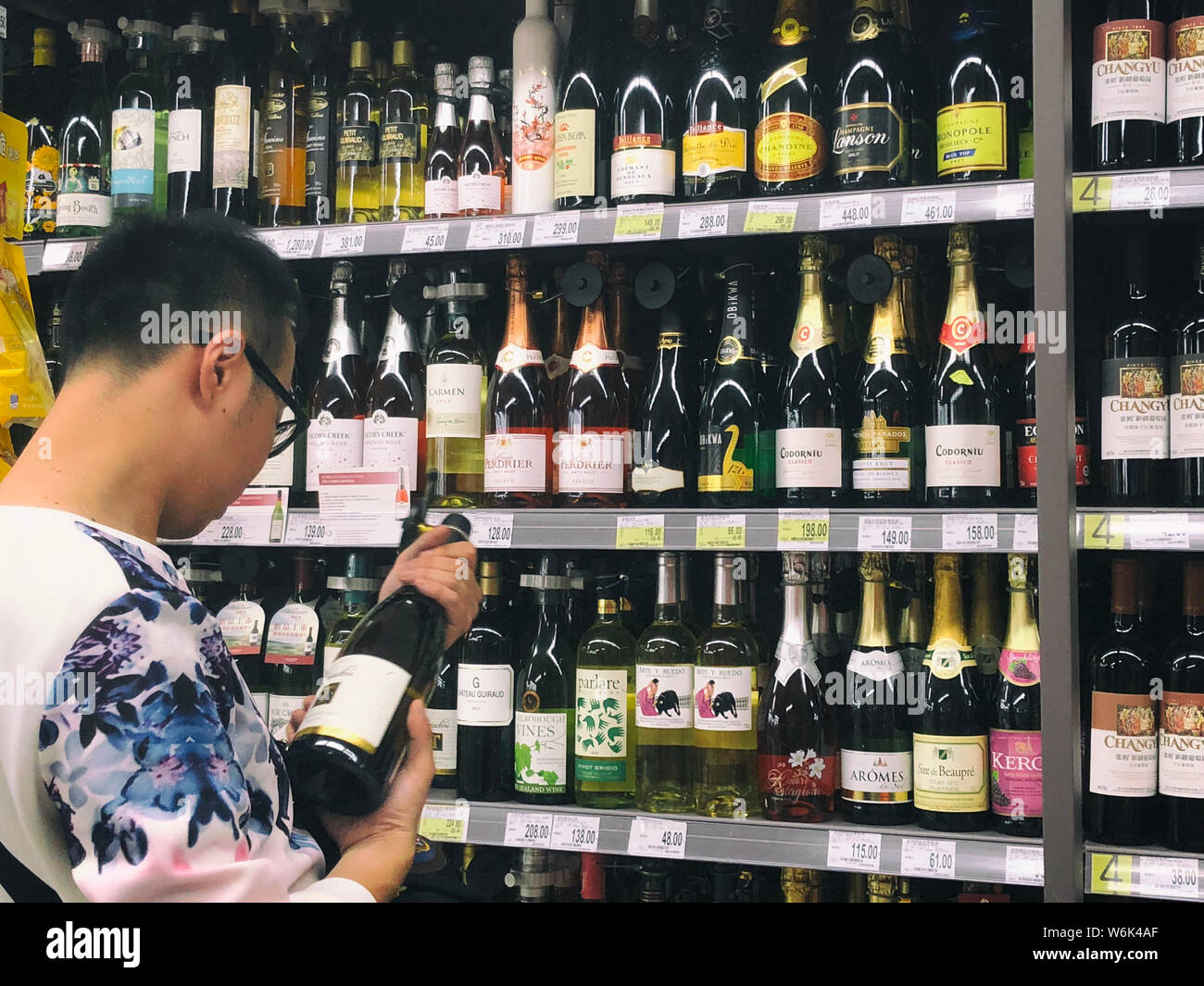 --FILE--A customer shops for wine at a supermarket in Shanghai, China, 11 November 2017. China is likely to displace Britain as the world's second lar Stock Photo