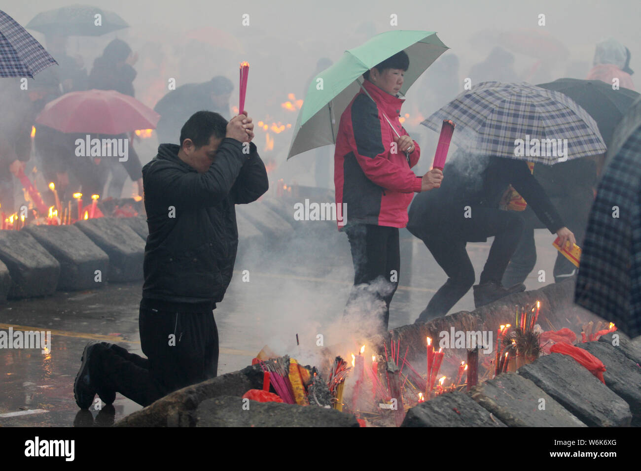 Chinese worshippers burn incense sticks to pray for wealth and ...