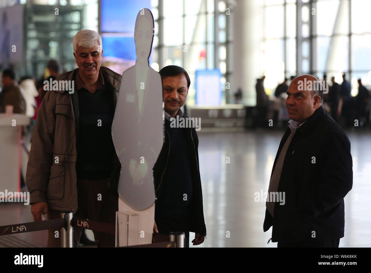 Passengers look at a hologram of real-life customer service staff at the Shenyang Taoxian International Airport in Shenyang city, northeast China's Li Stock Photo