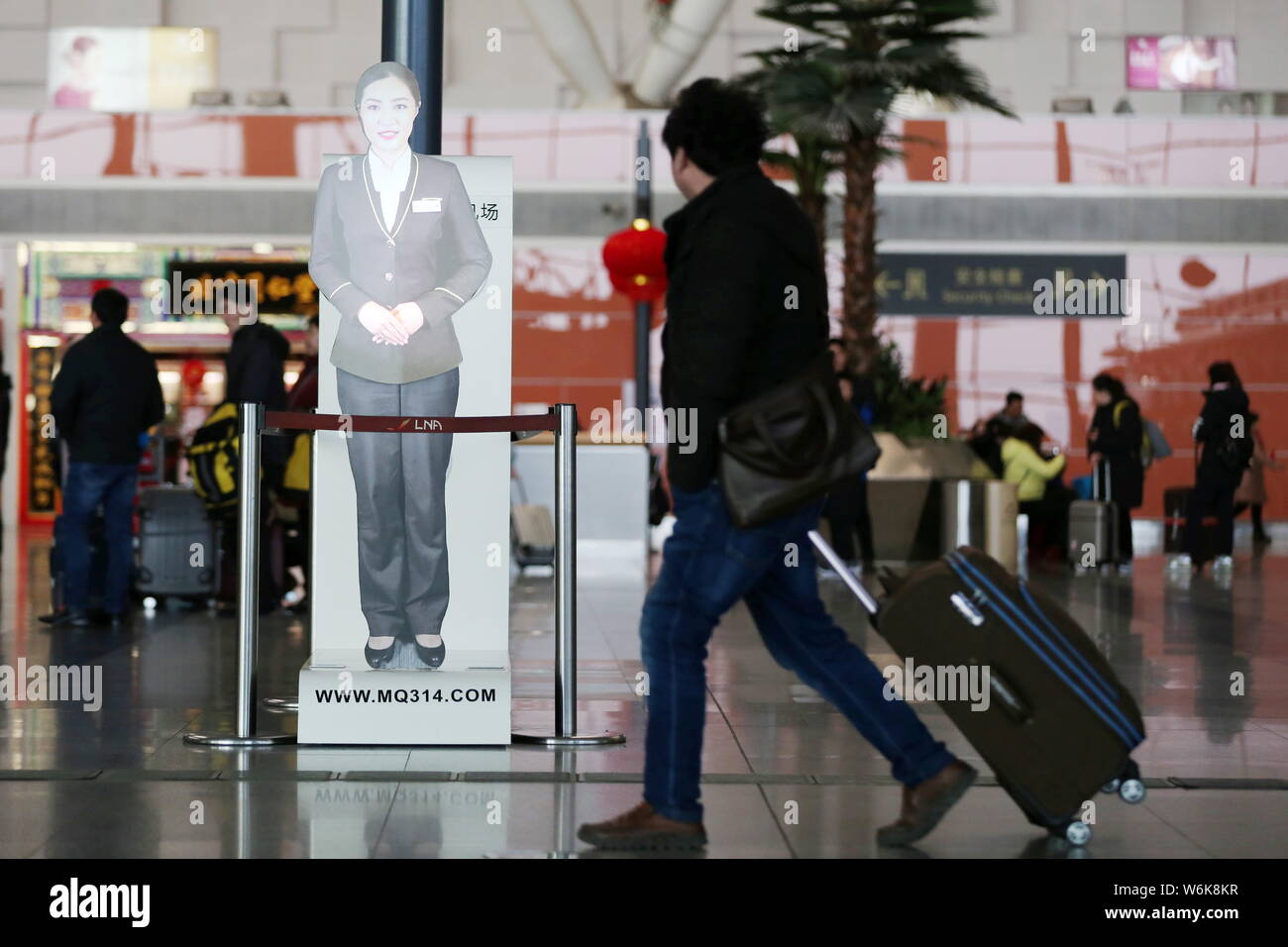 A passenger walks past a hologram of reallife customer service staff at the Shenyang Taoxian