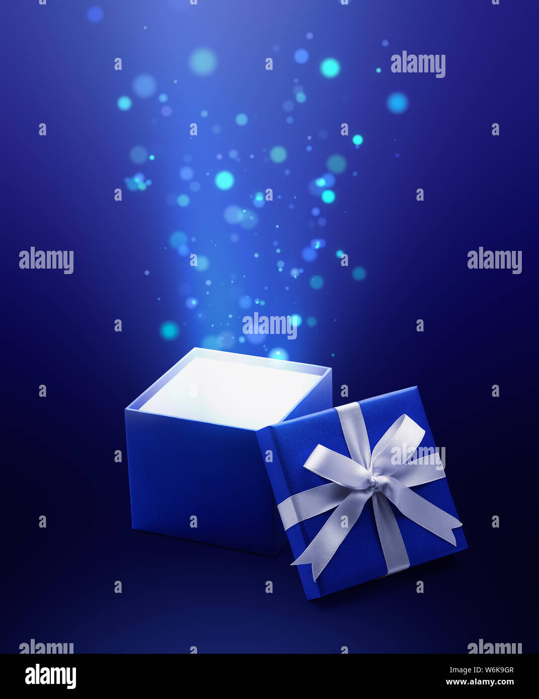 Blue open gift box with magical light Stock Photo - Alamy