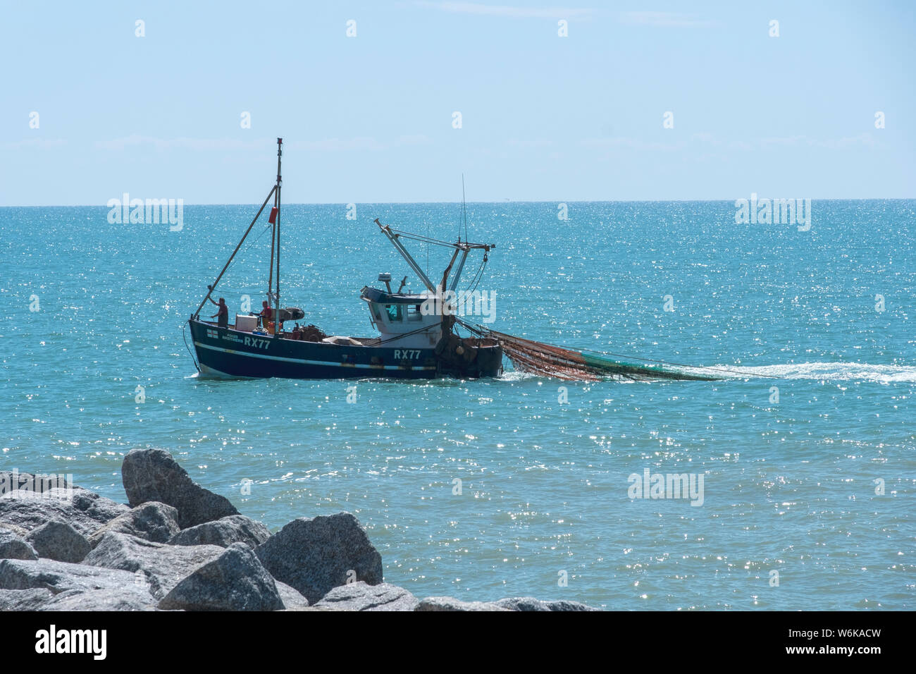 Hastings fishing trawler with trawl nets out close to shore, East Sussex, UK Stock Photo