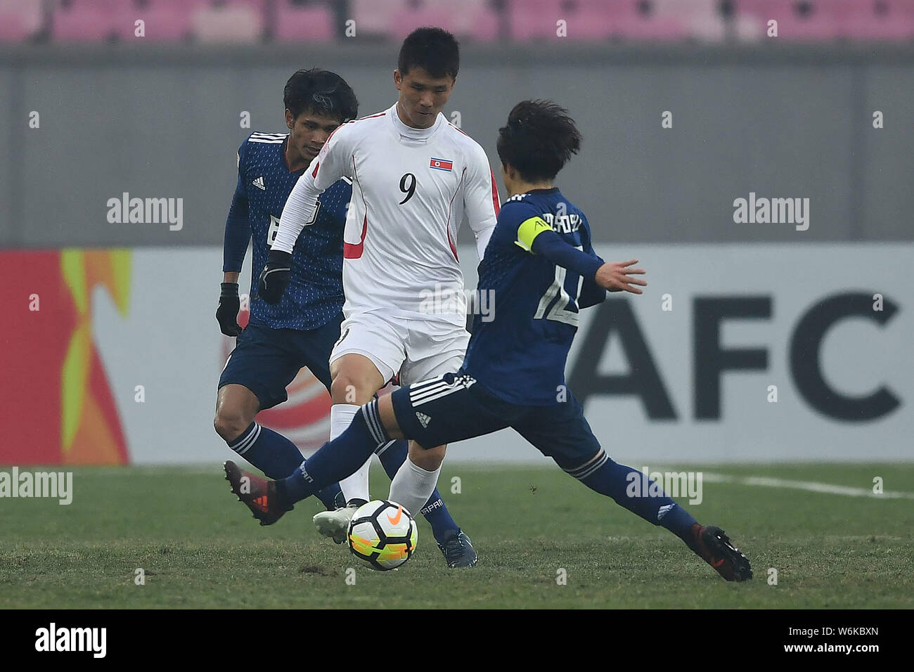Tsukasa Morishima, left, and Koji Miyoshi, right, of Japan challenge Kim Yu-song of North Korea in their Group B match during the 2018 AFC U-23 Champi Stock Photo