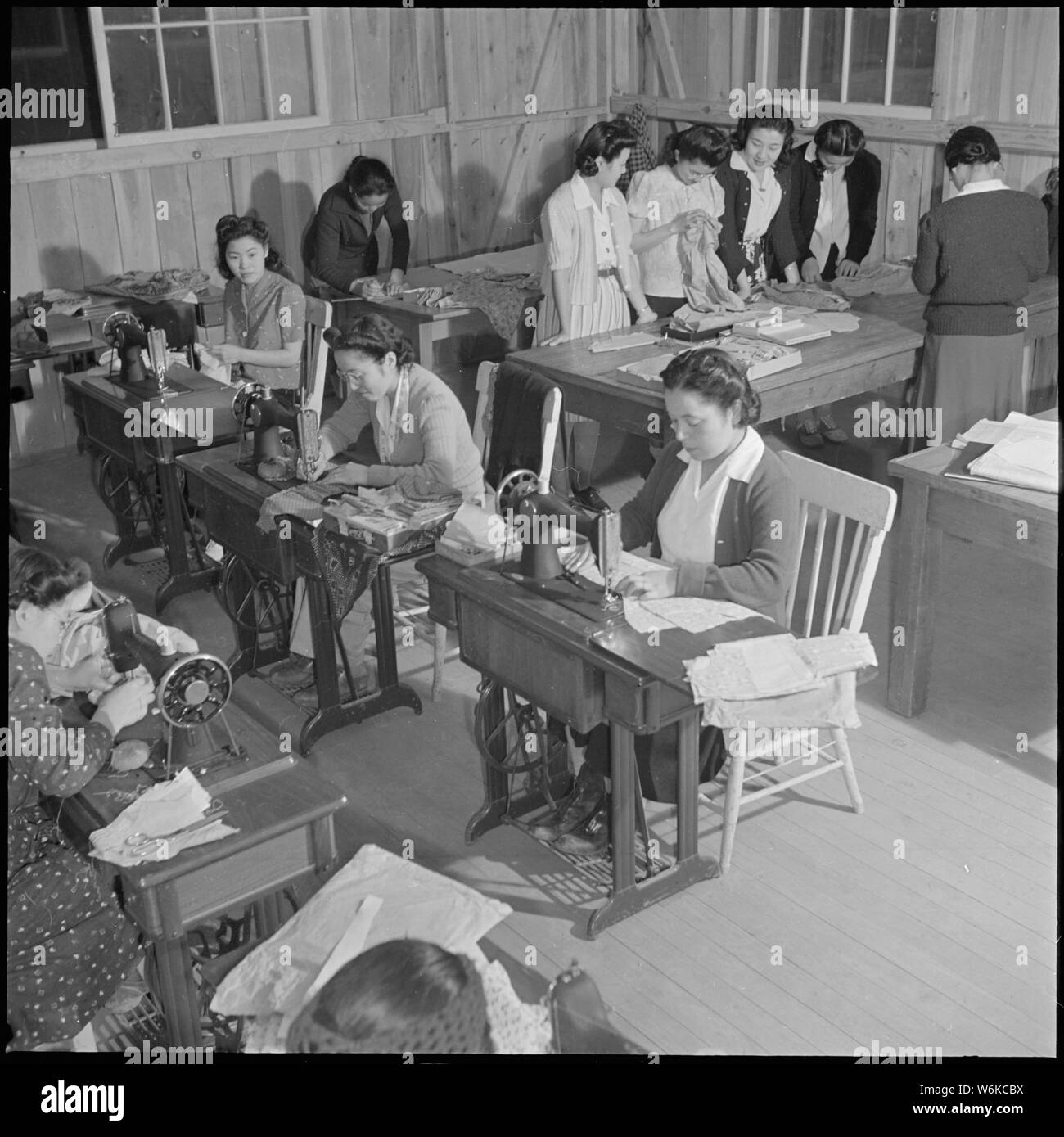 Rohwer Relocation Center, McGehee, Arkansas. A sewing class in the adult education division of the . . .; Scope and content:  The full caption for this photograph reads: Rohwer Relocation Center, McGehee, Arkansas. A sewing class in the adult education division of the Rohwer schools. This class is conducted by center residents, Mrs. Sadako Yasue, a qualified Home Economics Teacher, who, with other assistant teachers, have been recruited from among center residents, former west coast persons of Japanese ancestry. Stock Photo