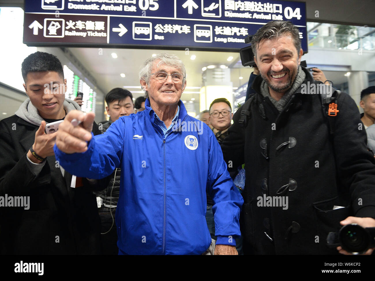 Serbian football coach and former player Bora Milutinovic, center, is surrounded by fans as he arrives at the Chengdu Shuangliu International Airport Stock Photo