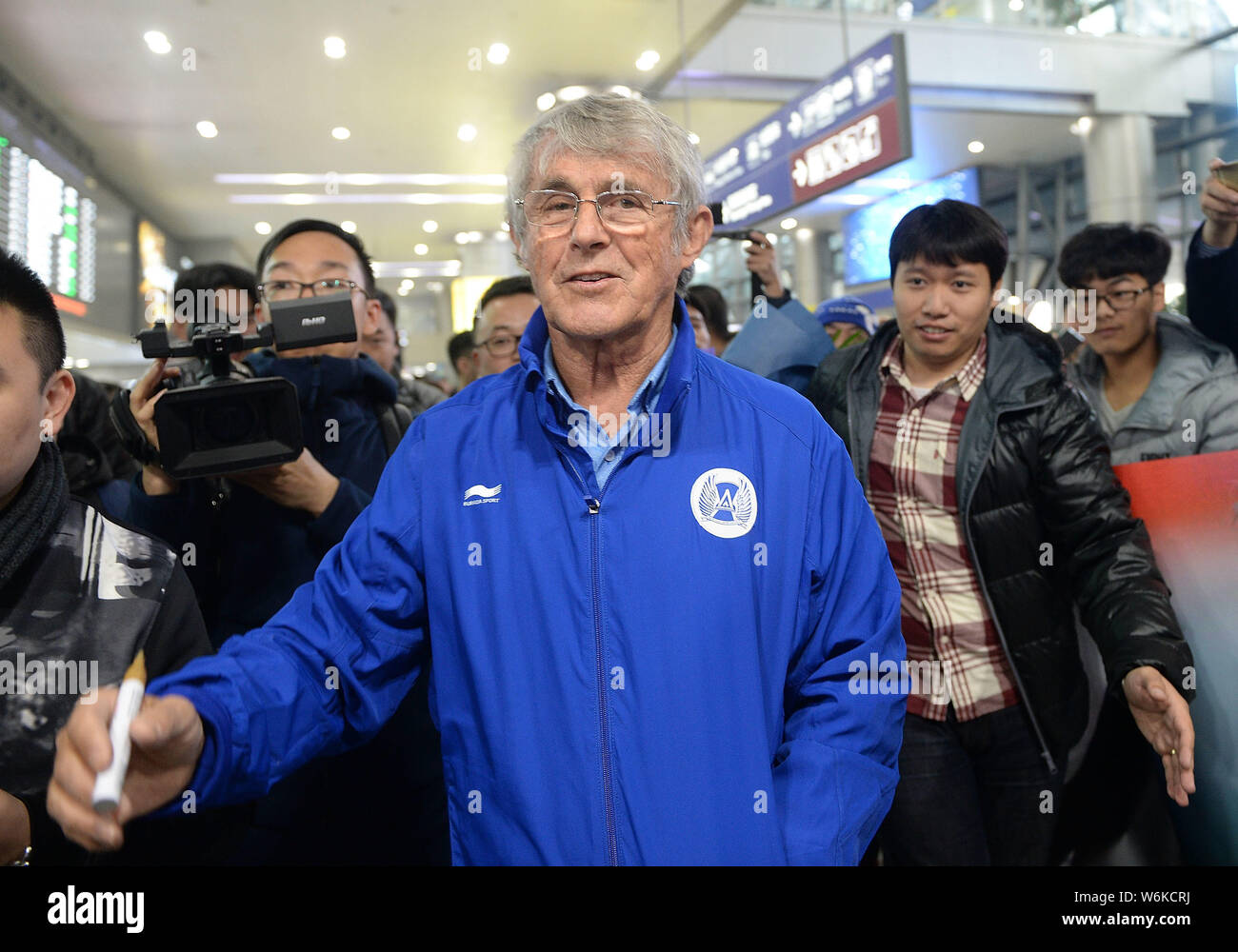 Serbian football coach and former player Bora Milutinovic, center, is surrounded by fans as he arrives at the Chengdu Shuangliu International Airport Stock Photo