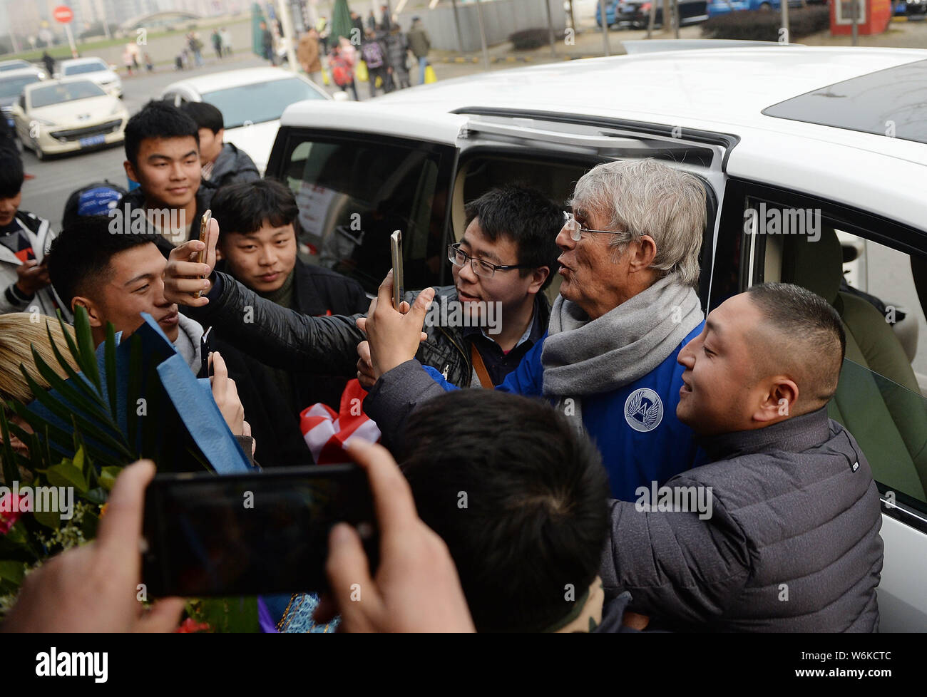 Serbian football coach and former player Bora Milutinovic, center, takes selfies with fans as he arrives at the Chengdu Shuangliu International Airpor Stock Photo