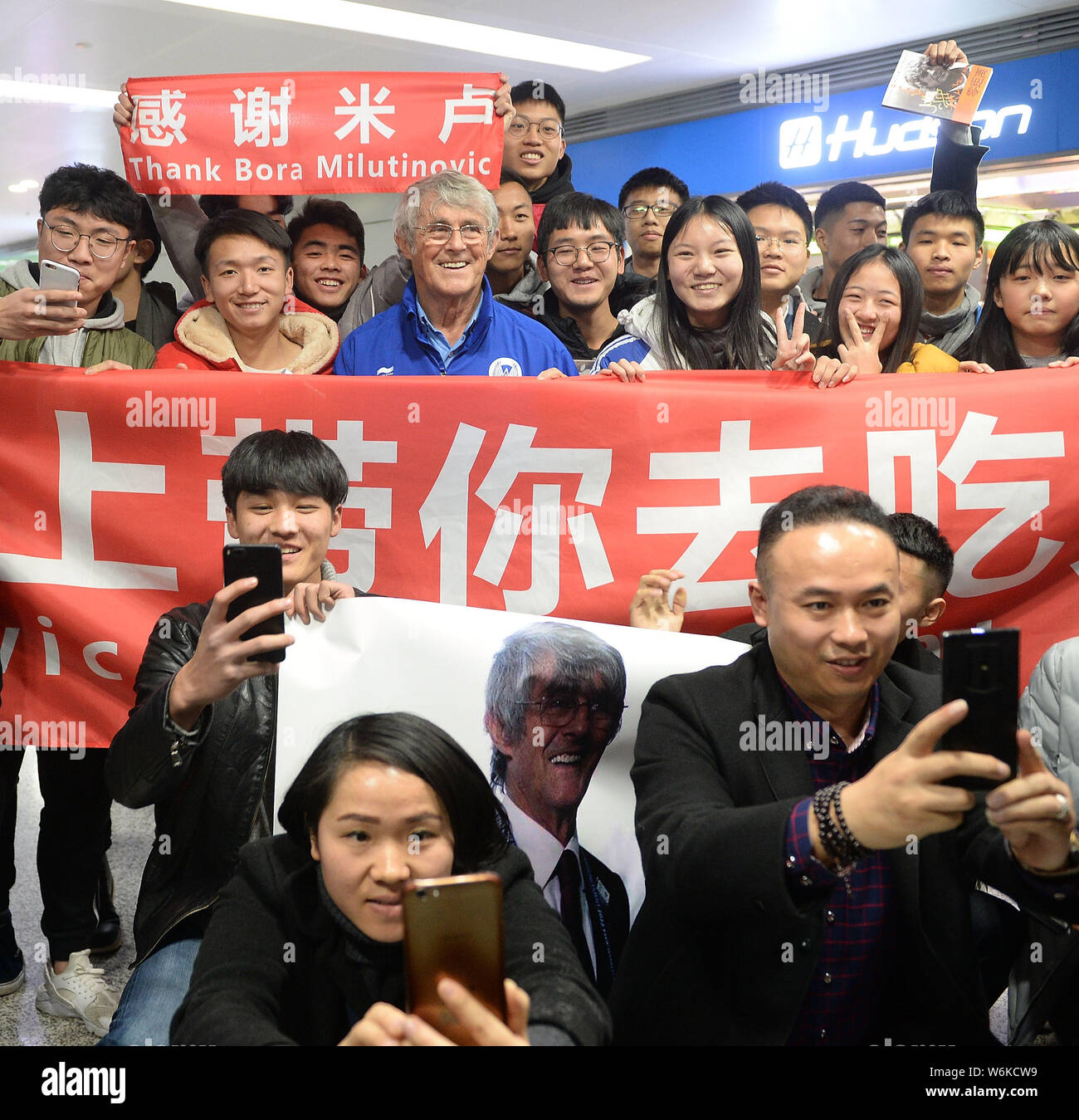 Serbian football coach and former player Bora Milutinovic, center, poses for photos with fans as he arrives at the Chengdu Shuangliu International Air Stock Photo