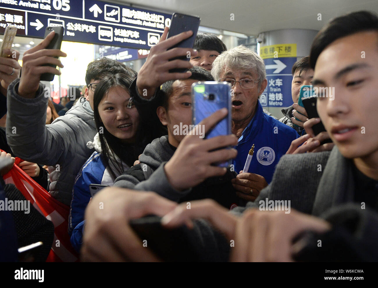 Serbian football coach and former player Bora Milutinovic, center, takes selfies with fans as he arrives at the Chengdu Shuangliu International Airpor Stock Photo