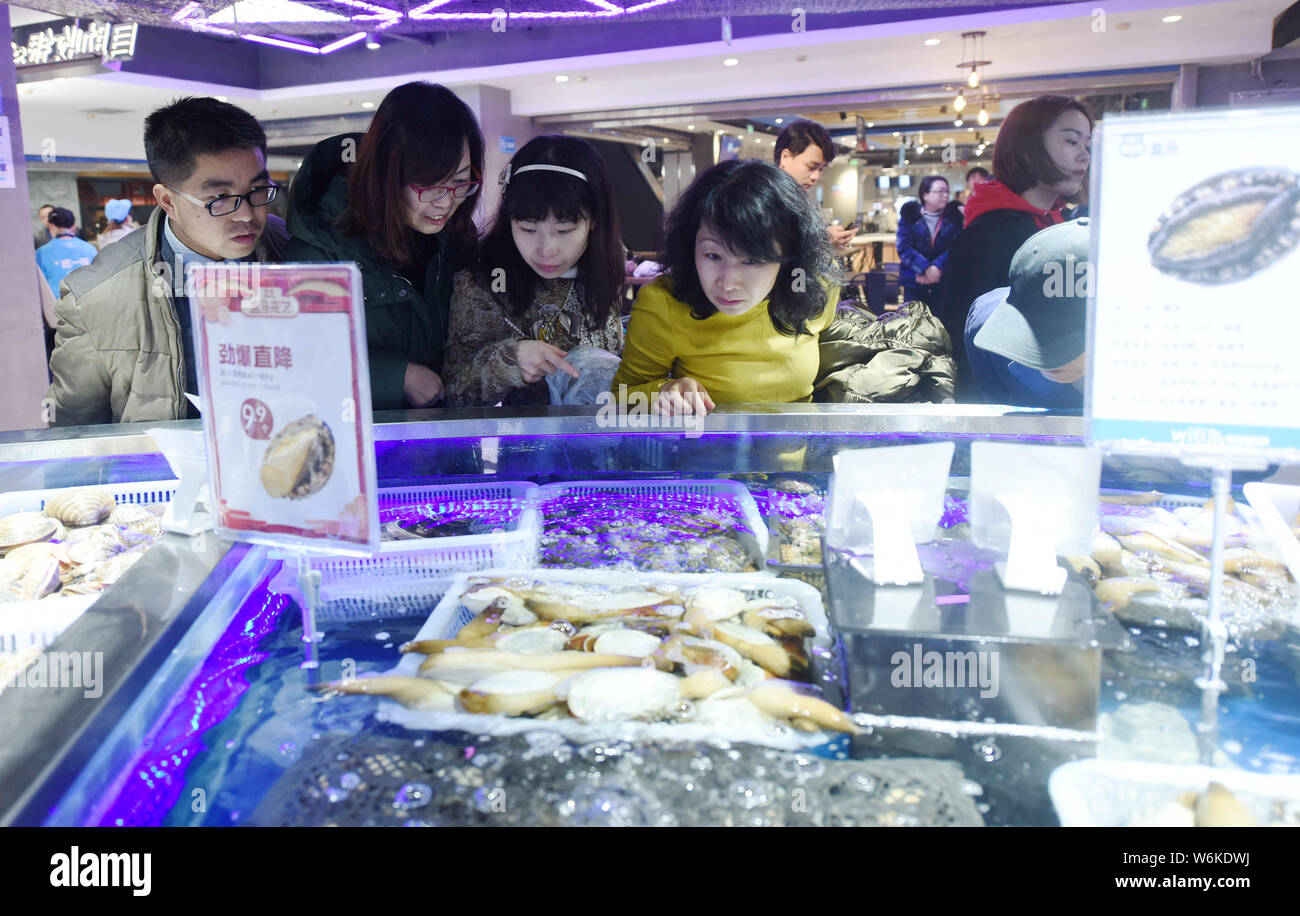 Chinese customers shop for seafood at the new flagship store of O2O fresh produce retailer