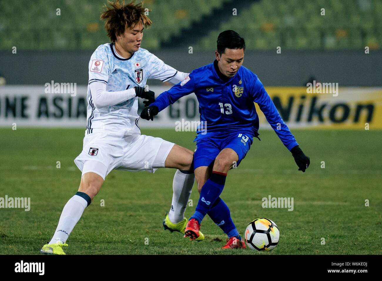 Itakura Kou, left, of Japan challenges Phicha Au-Tra of Thailand in their Group B match during the 2018 AFC U-23 Championship in Jiangyin city, east C Stock Photo
