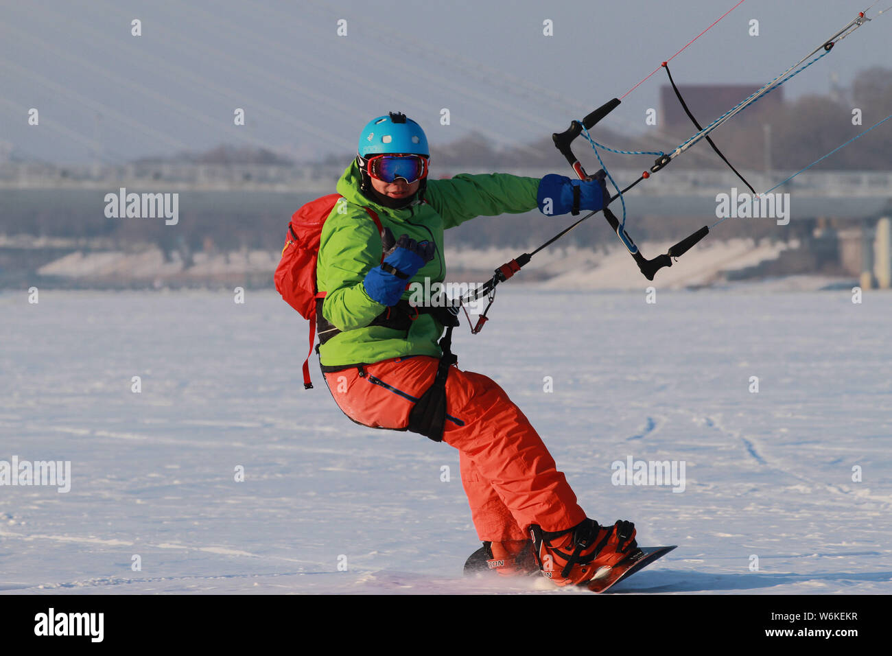 A snowkiter uses a large kite to glide on snow in Harbin city, northeast China's Heilongjiang province, 4 January 2018.      Snowkiting or Kite skiing Stock Photo