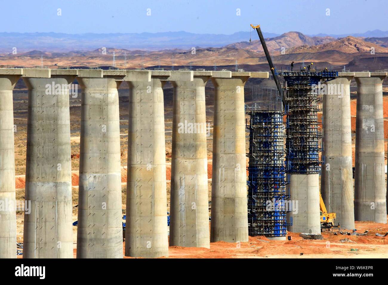 Chinese workers construct piers for the Ha'e (HamiEjina) Railway in