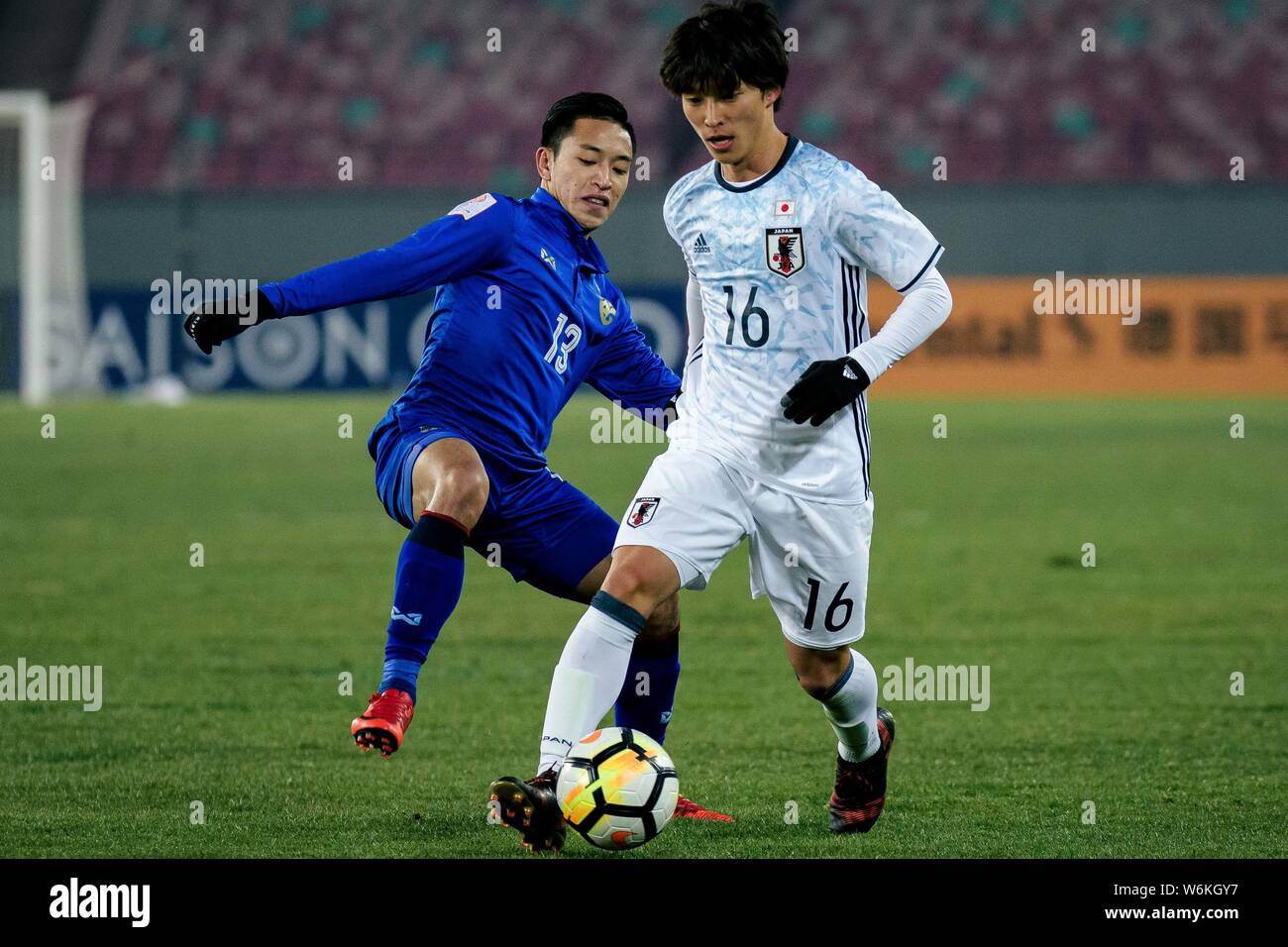 Shion Inoue, right, of Japan kicks the ball to make a pass against Phicha Au-Tra of Thailand in their Group B match during the 2018 AFC U-23 Champions Stock Photo