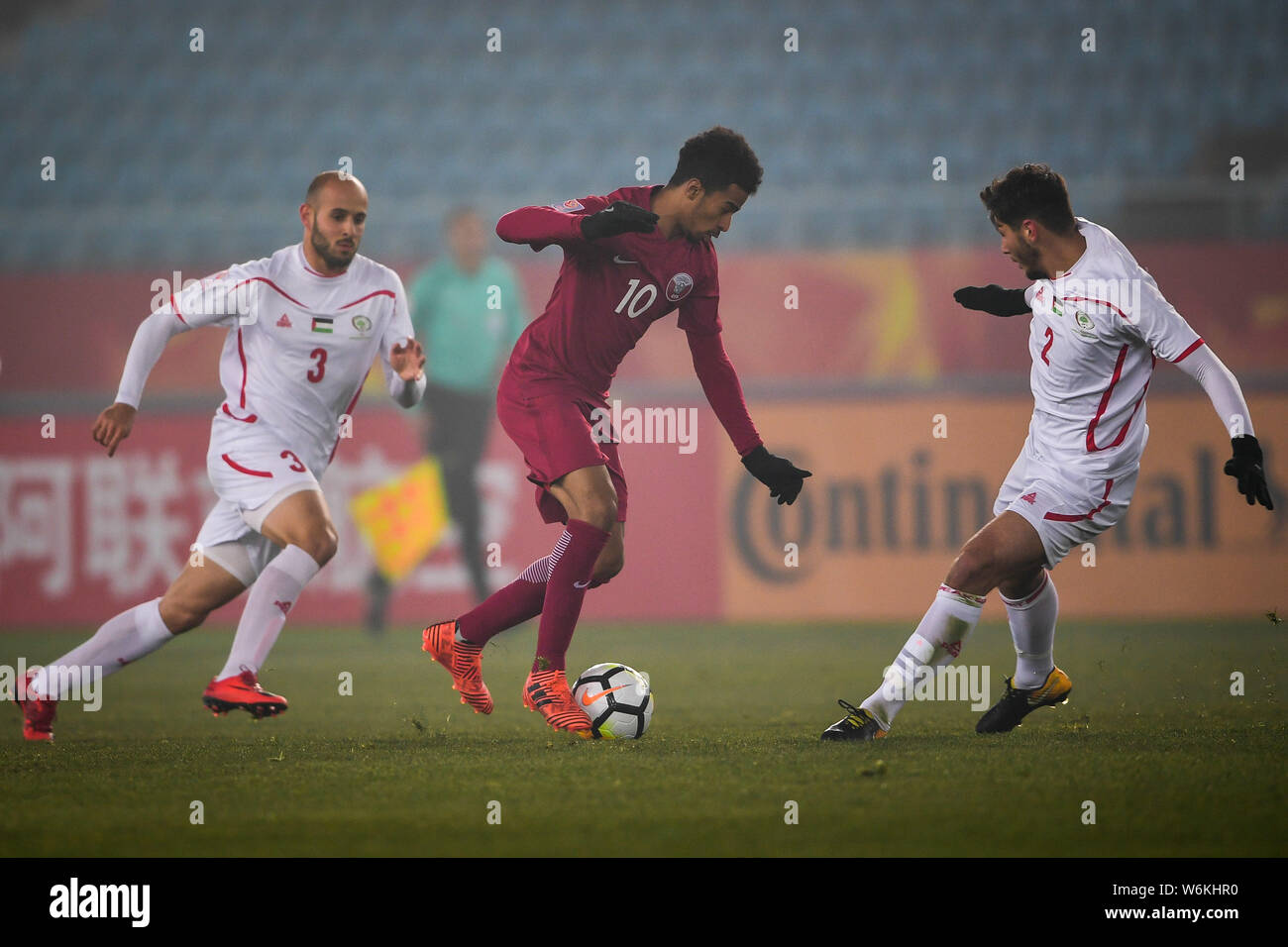 Akram Hassan Afif Yahya Afif of Qatar, center, dribbles against Palestine in the quarterfinal match during the 2018 AFC U-23 Championship in Jiangyin Stock Photo