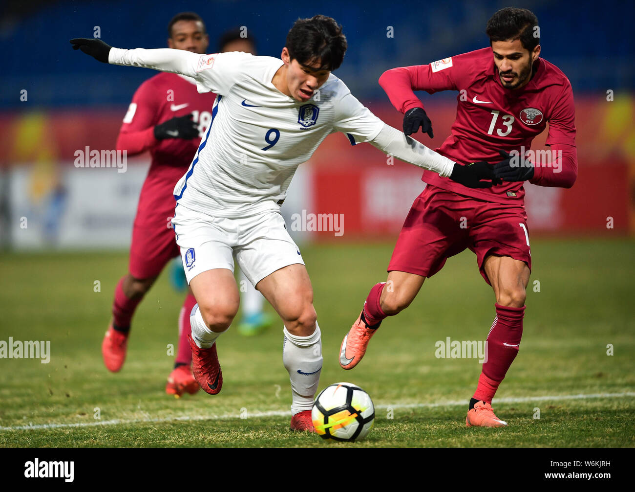 Lee Keun-ho, left, of South Korea kicks the ball to make a pass against Sultan Al-Brake of Qatar in their final match to fight for the third place dur Stock Photo