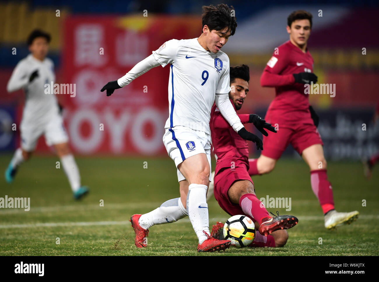 Lee Keun-ho, left, of South Korea kicks the ball to make a pass against a player of Qatar in their final match to fight for the third place during the Stock Photo