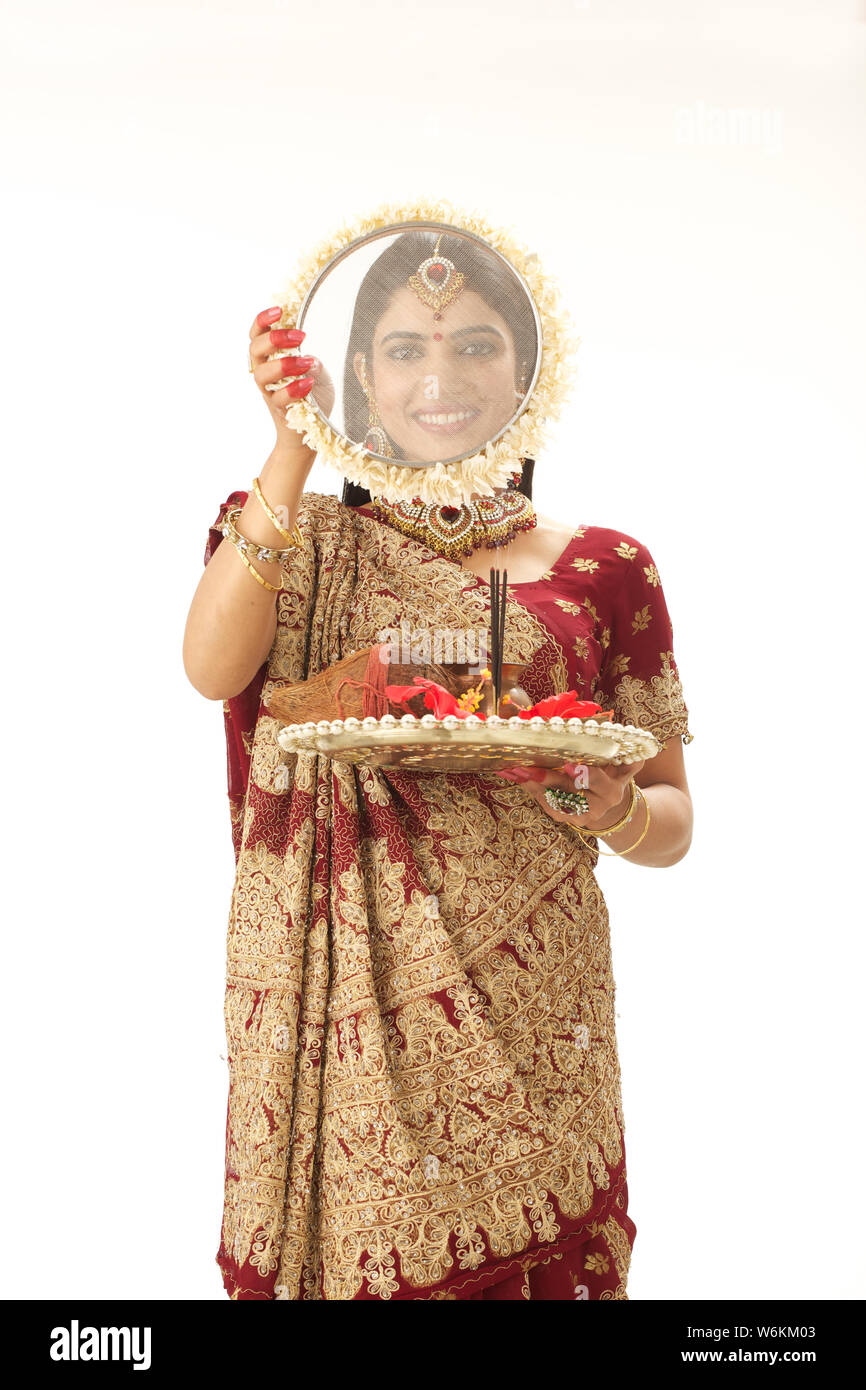 Woman looking through sieve during karwa chauth Stock Photo