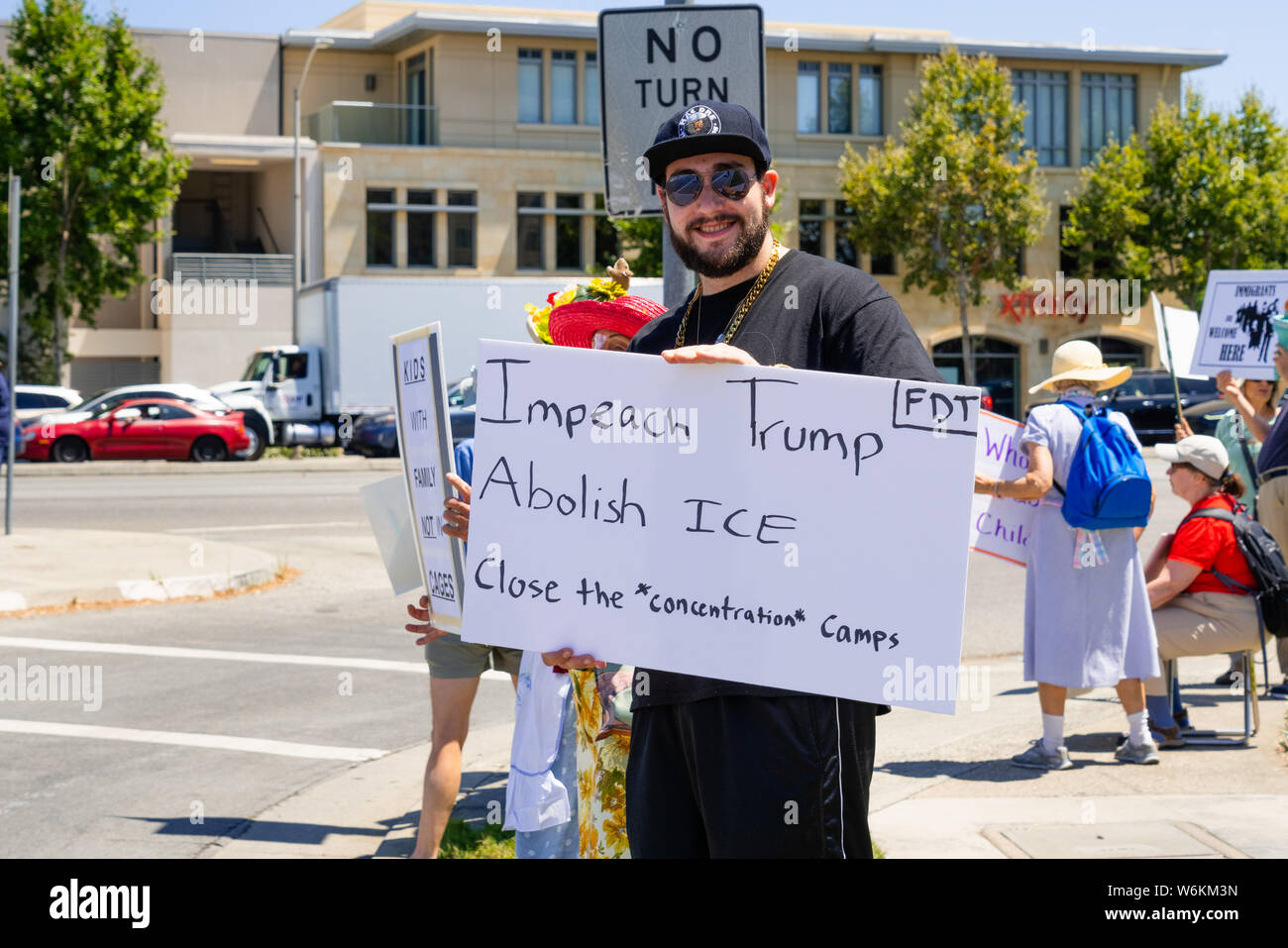 July 26, 2019 Palo Alto / CA / USA - Protester holding a sign with the messages 'Impeach Trump', 'Abolish ICE' and 'Close the concentration camps' Stock Photo