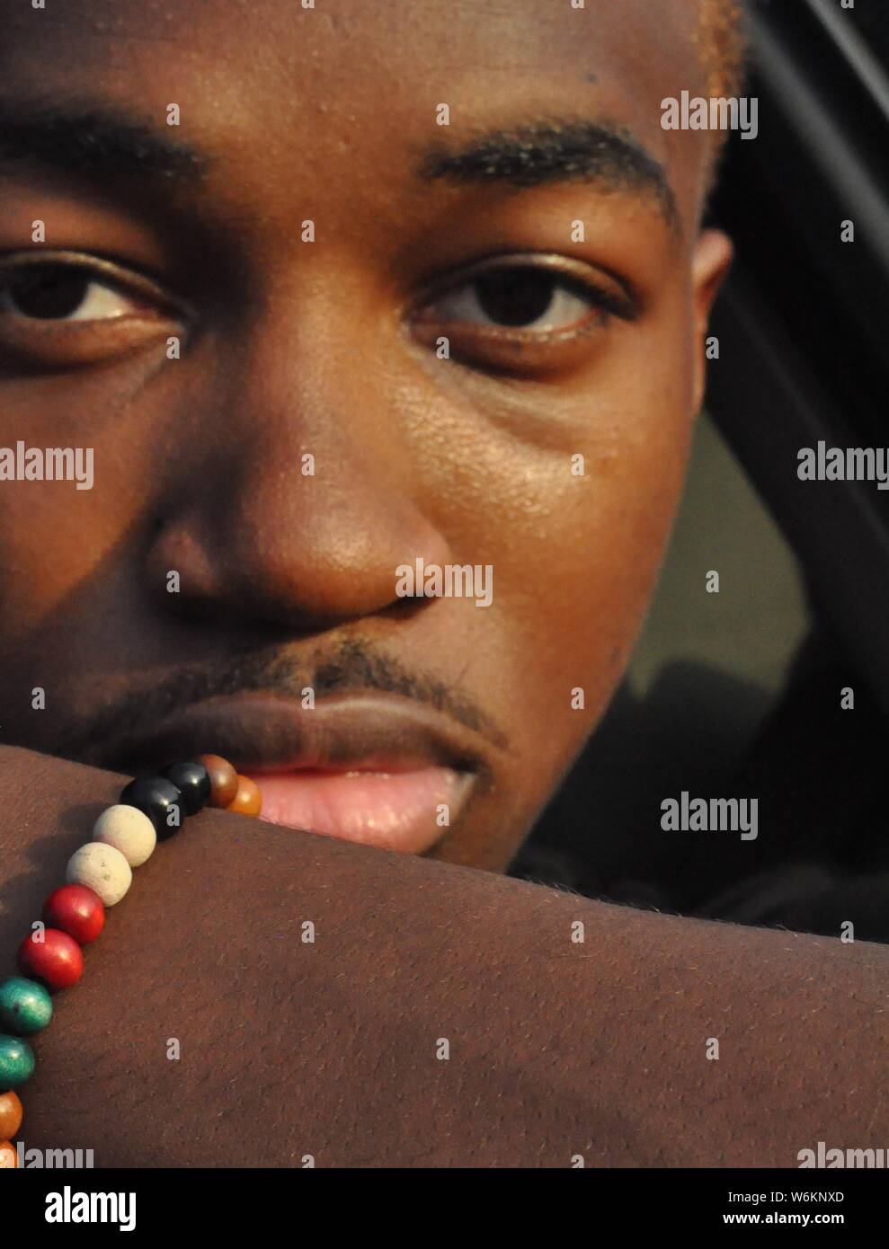 man taking picture of himself with a colorful bracelet Stock Photo