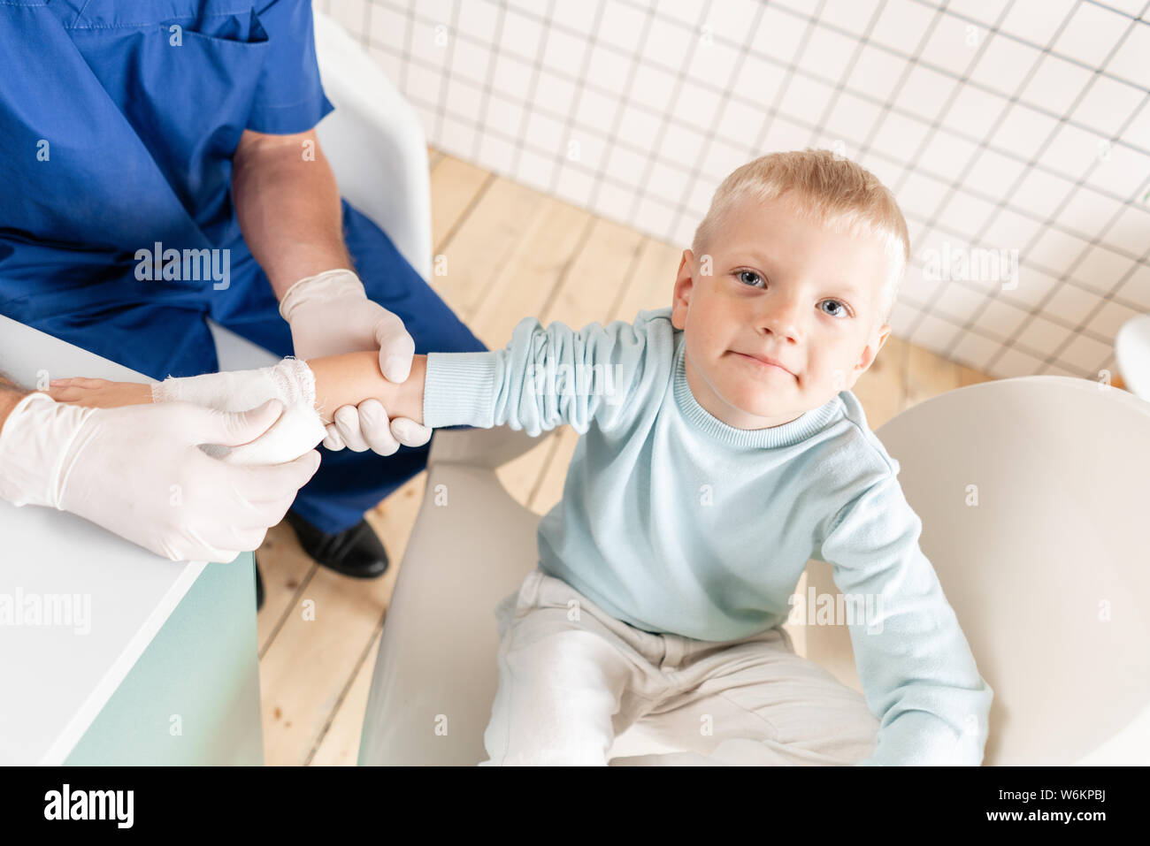 Sports injury. Doctor makes bandage on hand patient, in the hospital Stock Photo