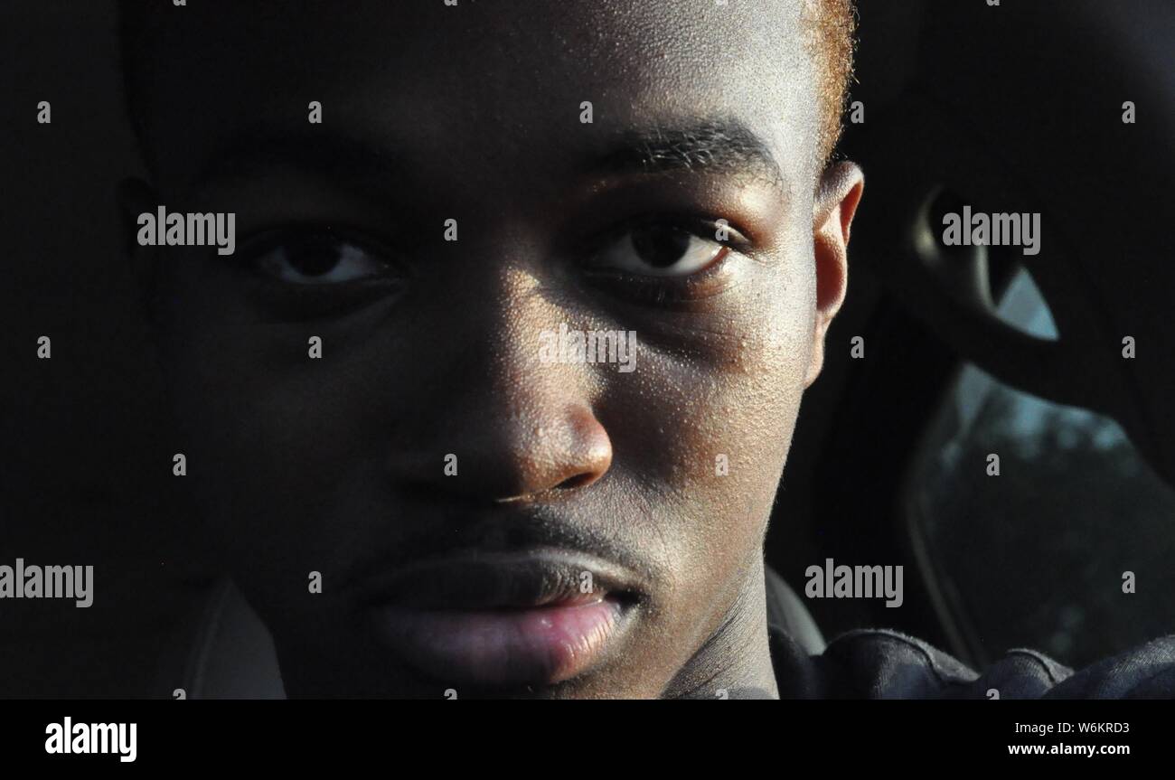 young man staring into the camera while taking a picture of himself Stock Photo