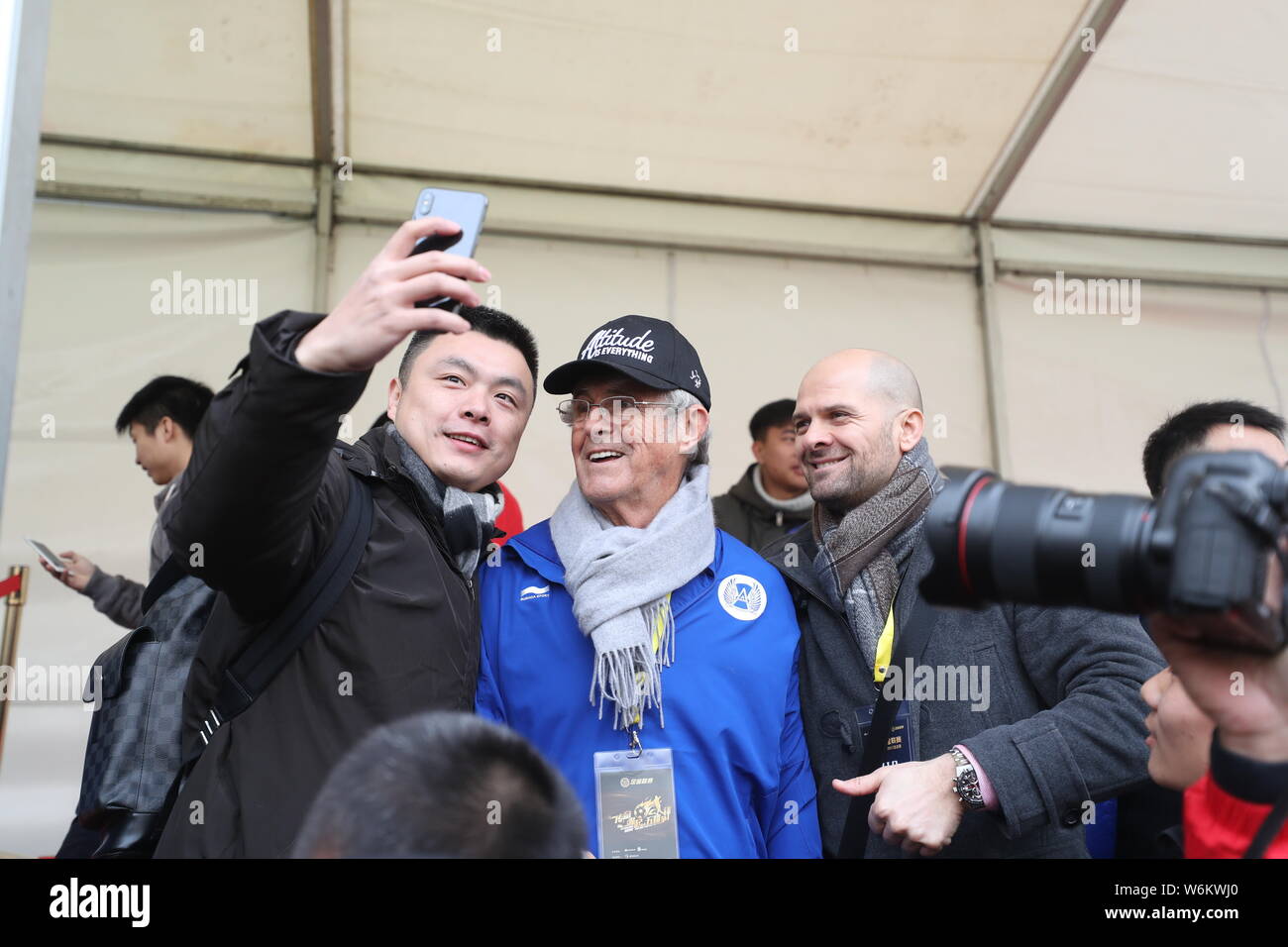 Serbian football coach and former player Bora Milutinovic, center, poses with fans for photos at a press conference of Sina 5v5 Football Golden League Stock Photo