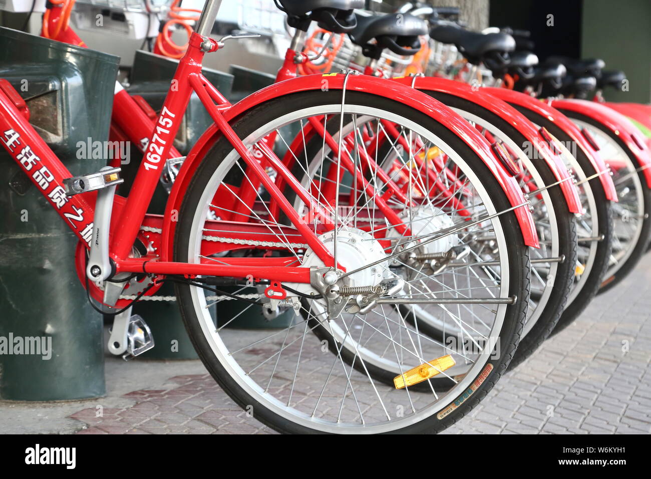 Red colored solar powered bikes are lined up at a public bike