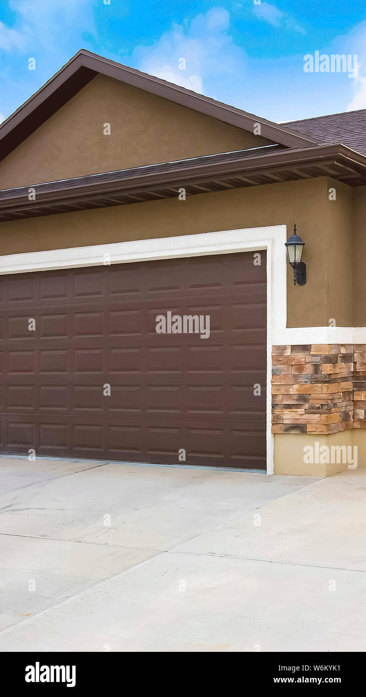 Vertical Frame Exterior Of A Home With Two Brown Garage Doors
