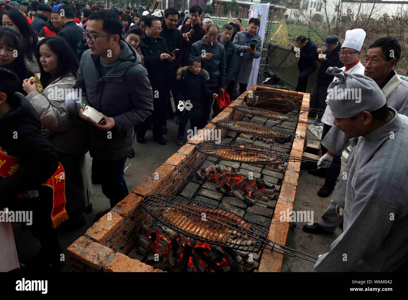 Chinese chefs roast fish during the ninth Fishing and Cultural Festival in Digang Fishing Village, Huzhou city, east China's Zhejiang province, 6 Janu Stock Photo