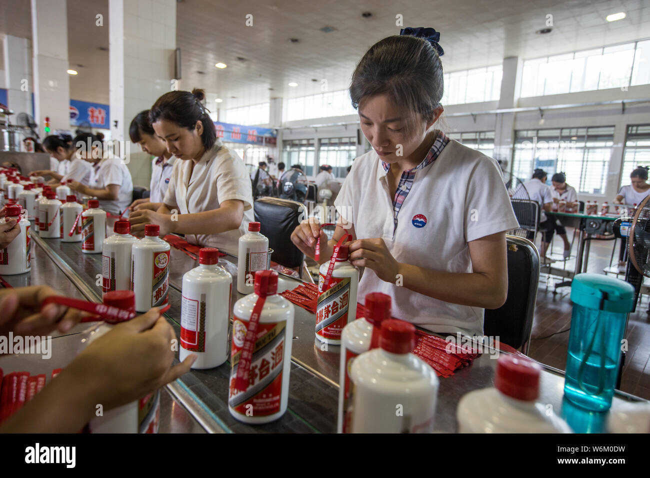 --FILE--Chinese workers produce bottles of Moutai, a Chinese brand of baijiu liquor, on the assembly line at a production plant of Kweichow Moutai in Stock Photo