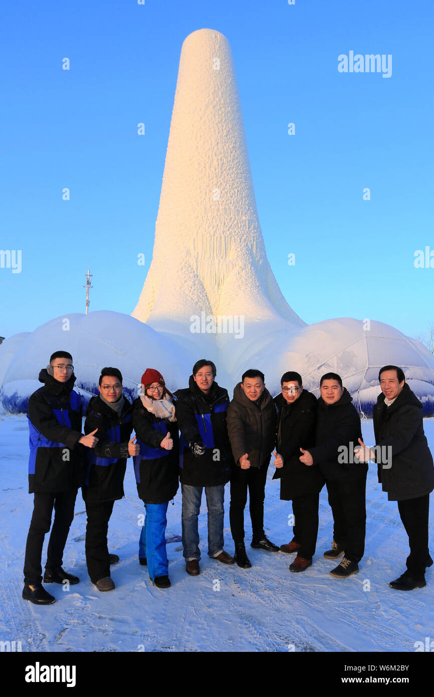 Tourists poses for photos with the world's tallest ice tower, which is