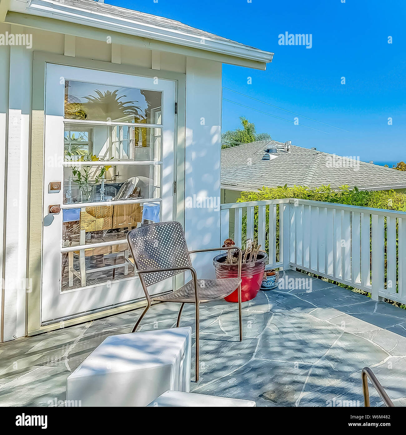 frame Chairs and barbecue grill at the balcony of a home with white